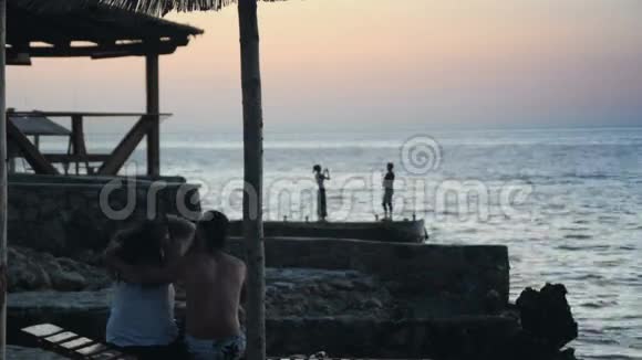 可爱的一对夫妇在海滩上聊天看日落视频的预览图