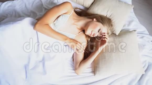 美丽的女孩睡在白色的床上看到早晨的梦视频的预览图