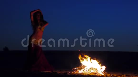 布鲁内特在炉火旁跳舞伴着美丽的日落视频的预览图