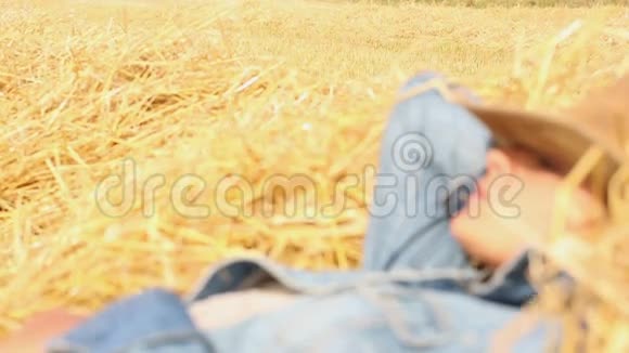 带着牛仔帽躺在干草里的和平女人视频的预览图