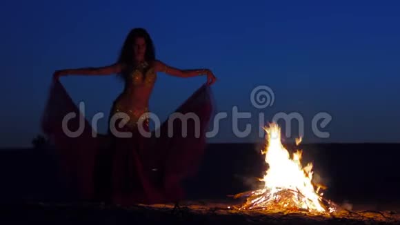 布鲁内特在炉火旁跳舞伴着美丽的日落视频的预览图