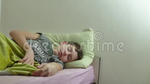 十几岁的男孩睡在床上一个疲惫的室内青年视频的预览图