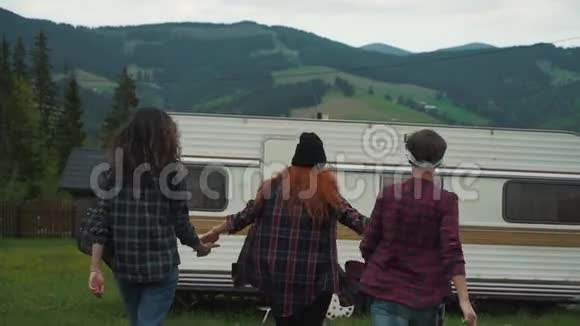 女孩们牵着手走在山里的拖车附近视频的预览图