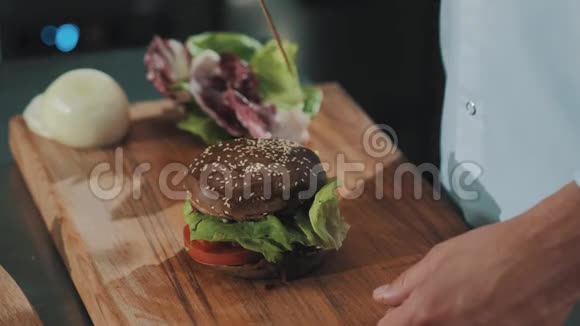 厨师把扦子放入麦面包汉堡包中咬一口视频的预览图