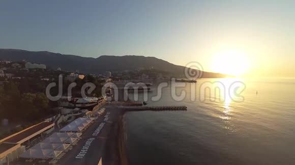 无人机的录像克里米亚2017年夏天日落时分在黑海下飞行海滩码头和山脉没有人视频的预览图
