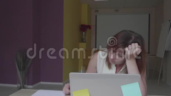 失望的女孩坐在笔记本电脑前写和扔纸有关视频的预览图