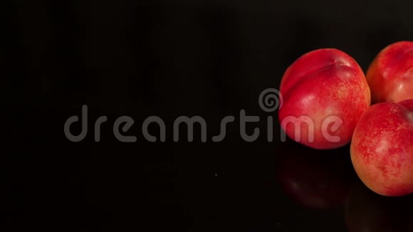 三个成熟的桃子在黑色的背景上视频的预览图
