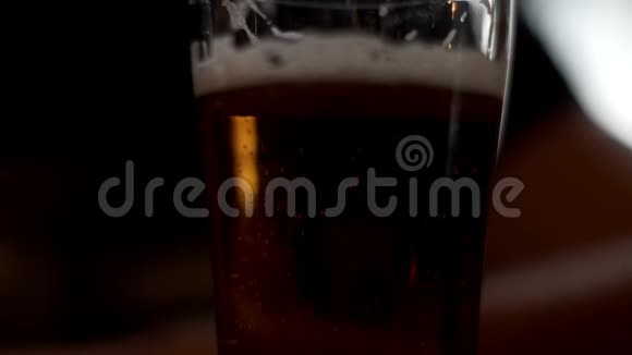 啤酒杯站在桌子上男子手拿玻璃啤酒喝酒吧视频的预览图
