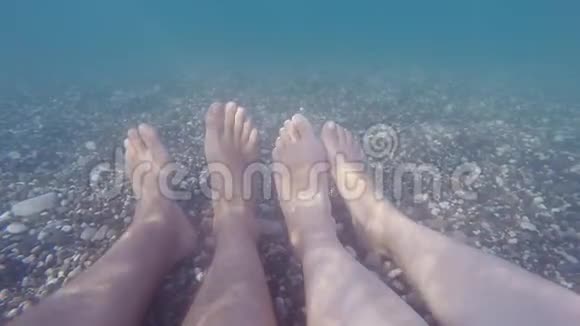 雌雄双脚水下在海上一对夫妇在暑假在海滩上放松观点POV关闭视频的预览图