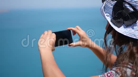 一个女孩戴着一顶漂亮的蓝色帽子美丽的蓝色海洋和海岸高清1920x1080慢动作视频的预览图
