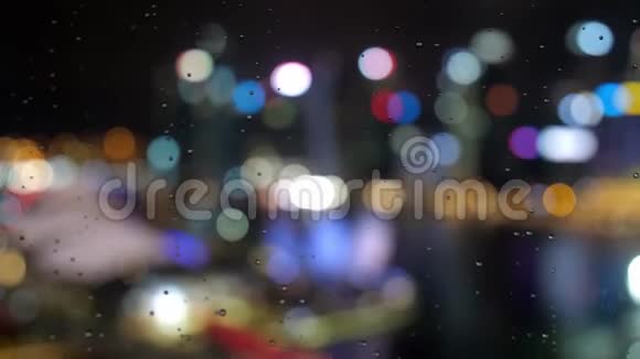 带有办公楼的抽象模糊光线和窗户上有雨滴的新加坡夜景视频的预览图