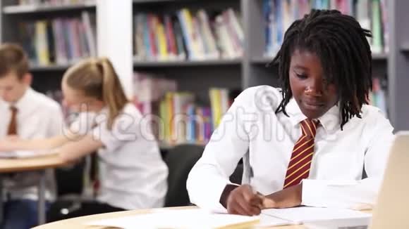 穿着统一制服在笔记本电脑上工作的女高中生视频的预览图