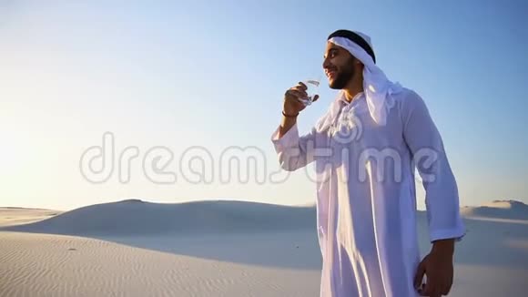 沙质沙漠干燥气候中男性穆斯林的清新气息盖伊阿伯打开杯子喝水视频的预览图