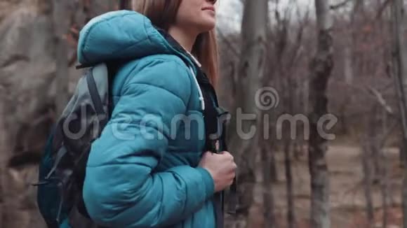 近距离观看年轻华丽的旅游女孩带着背包漫不经心地在秋天的森林里好奇秋季视频的预览图