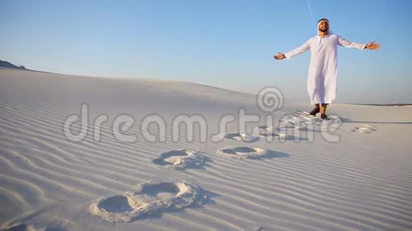 阿联酋酋长兴高采烈地在沙地沙漠中漫步在大自然中在露天享受晴朗的一天视频的预览图