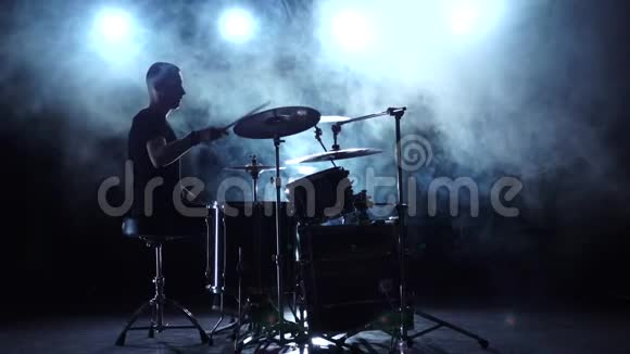 音乐家用棍子在鼓上演奏专业的好音乐烟熏背景剪影慢动作视频的预览图
