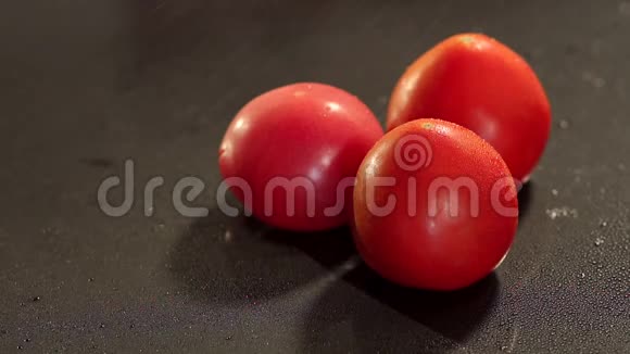 三个西红柿水溅在黑色上视频的预览图