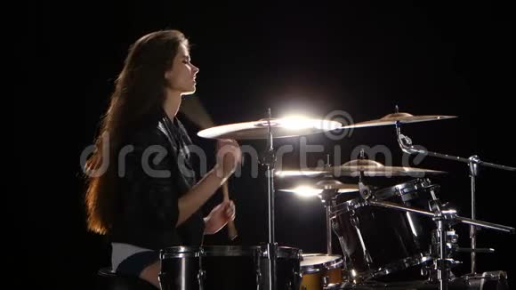 拿着筷子的女鼓手敲打有节奏的音乐黑色背景侧视图视频的预览图