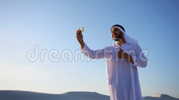 阿拉伯酋长男子的肖像带有小玩意在夏日与蓝天视频交流视频的预览图