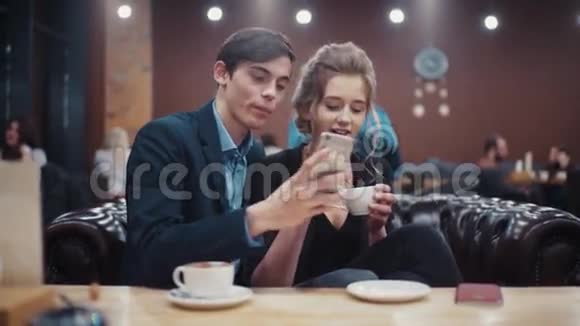 年轻夫妇拍自画像照片亲吻笑和享受对方在城市咖啡馆A约会视频的预览图