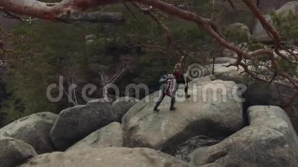 一对年轻夫妇在空中漫步从岩石山顶爬下来手牵着手视频的预览图