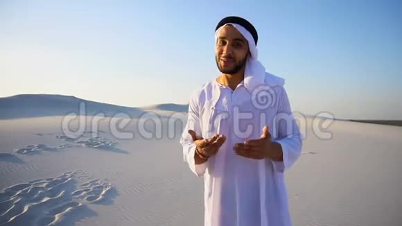 阿拉伯男子广告代理看着相机告诉信息握手站在广阔的沙漠中间视频的预览图