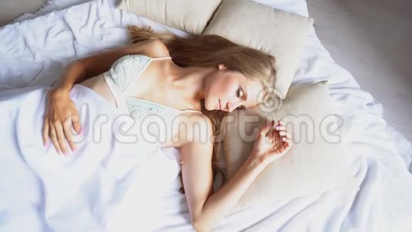 美丽的女孩睡在白色的床上看到早晨的梦视频的预览图
