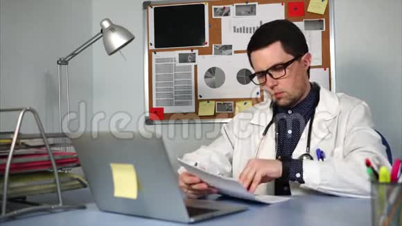 在工作场所工作的医生带着笔记本和医疗表格视频的预览图