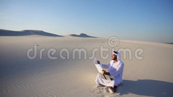受过教育的男性穆斯林阿拉伯阿联酋谢赫建筑师坐在手中拿着小玩意和图纸为视频的预览图
