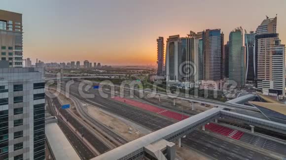 日出期间在迪拜码头和迪拜JLT时间推移附近的SheikhZayed道路的高空俯视视频的预览图