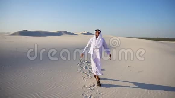 开朗的年轻男性阿拉伯阿联酋酋长酋长酋长国生活愉快在晴朗的夜晚穿过沙漠视频的预览图