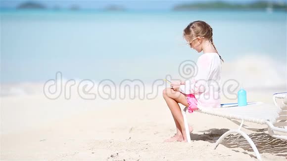 小女孩坐在日光浴床上用相机拍视频或照片视频的预览图