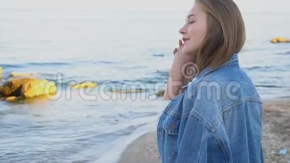 夏天迷人的女孩沿着海岸散步在沙滩上快乐地闲逛视频的预览图