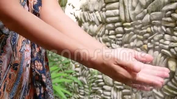 巴厘岛丛林喷泉水溅下女性洗手视频的预览图