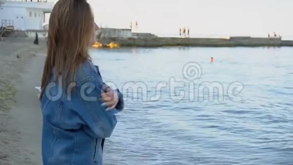 漂亮的女孩沿着海岸散步快乐就像夏天晚上在沙滩上的孩子一样视频的预览图