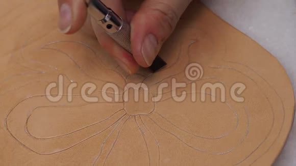 工匠用旋转刀在皮革上雕刻一朵花视频的预览图