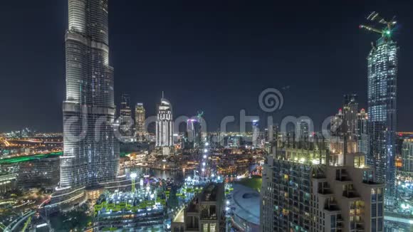 全景式的迪拜市区天际线景观带有购物中心喷泉和摩天大楼的空中夜景视频的预览图