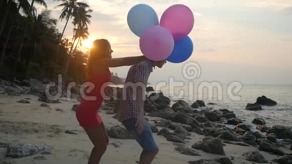 戏弄女孩跳回她男朋友身边恋爱中的情侣玩得开心拿着五颜六色的气球旋转视频的预览图