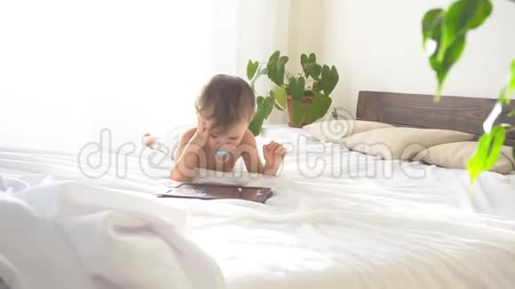 小儿子躺在卧室的床上看着上网板视频的预览图