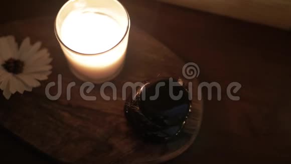 桌子上燃烧着蜡烛石头和鲜花视频的预览图