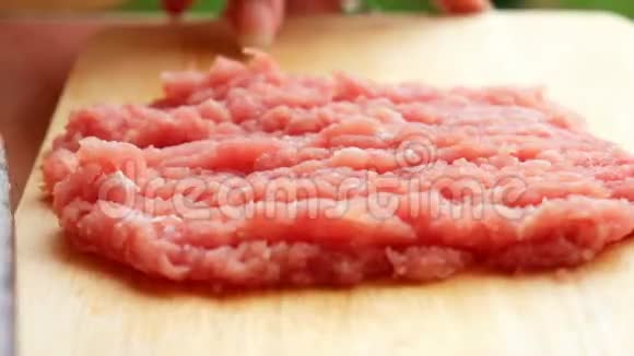 厨师正用锋利的刀在木切割板上切生猪肉以便在厨房里做饭视频的预览图