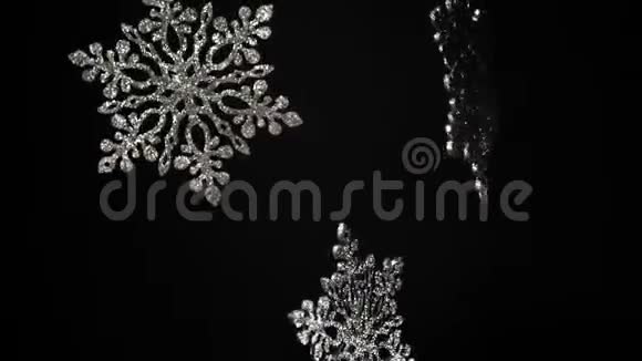 美丽的大装饰闪亮的雪花在黑色背景上旋转圣诞节或新年的概念树木装饰慢一点视频的预览图