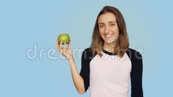 可爱漂亮的女人拿着美味多汁的苹果视频的预览图