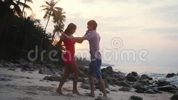 日落时分年轻的幸福夫妇在热带海滩上慢舞慢动作泰国苏梅岛1920x1080视频的预览图