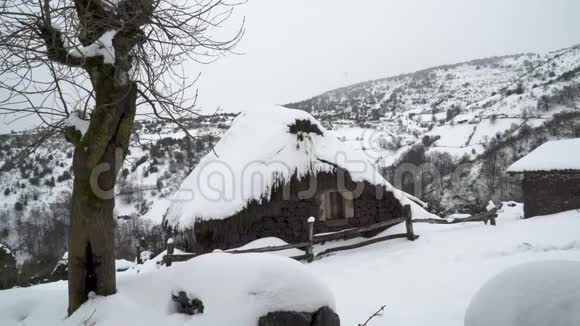 山上白雪覆盖的乡村小房子视频的预览图