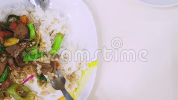 有人用叉子吃饭用肝脏吃米饭在白色的盘子上看食物视频的预览图