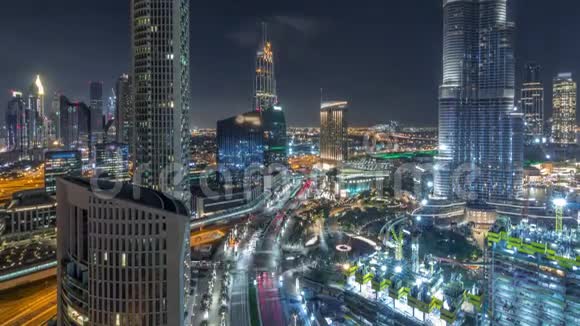 全景式的迪拜市区天际线景观带有购物中心喷泉和摩天大楼的空中夜景视频的预览图