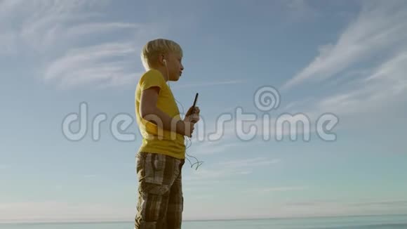 一个小男孩在海滩上表演的可爱的舞蹈视频的预览图