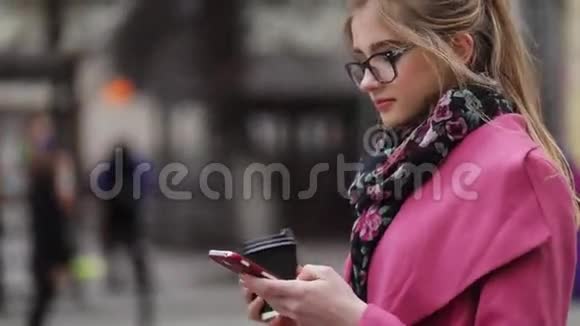 旋转视图的时尚女士拿着咖啡去和短信现代生活方式时髦的样子视频的预览图