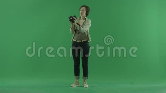 一位年轻女子正在绿色屏幕的前侧拍照视频的预览图